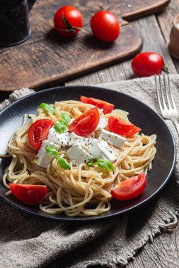 Tabakta peynirli ve domatesli spagetti. İtalyan makarnası