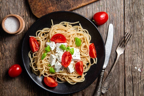stock image Spaghetti with feta cheese and tomatoes in a plate. Italian pasta