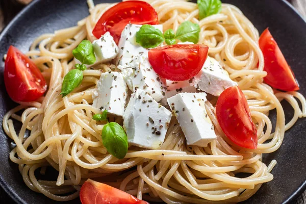 stock image Spaghetti with feta cheese and tomatoes in a plate. Italian pasta