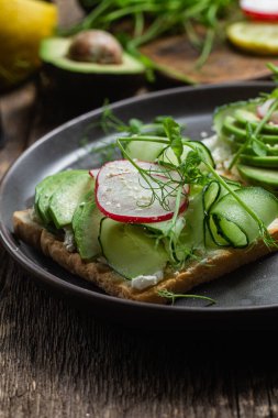 Krem peynirli beyaz ekmek tostu, avokado, salatalık ve turp.