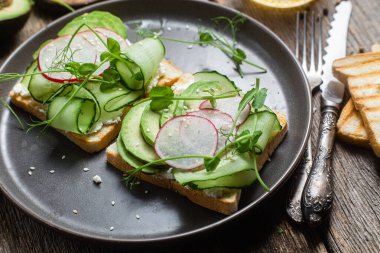 Krem peynirli beyaz ekmek tostu, avokado, salatalık ve turp.