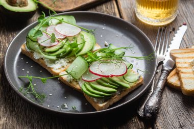 Krem peynirli beyaz ekmek tostu, avokado, salatalık ve turp.