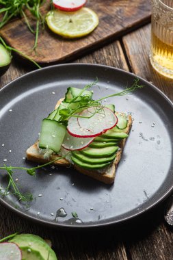 Krem peynirli beyaz ekmek tostu, avokado, salatalık ve turp.