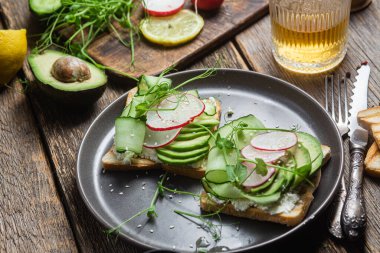 Krem peynirli beyaz ekmek tostu, avokado, salatalık ve turp.