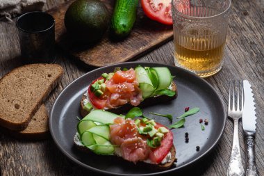 Tuzlu somon, krem peynirli, domatesli ve salatalıklı siyah ekmek sandviçi