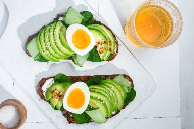 Krem peynirli sandviç, avokado ve beyaz arka planda haşlanmış yumurta.