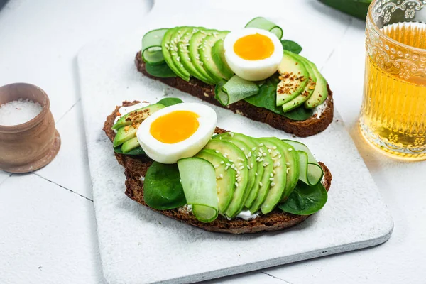 stock image Sandwich with cream cheese, avocado and boiled egg on a white background