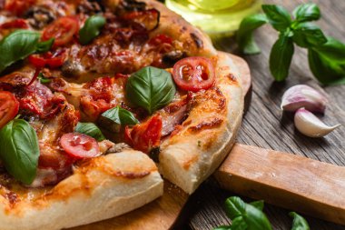 İştah açıcı pizza. Jambonlu, mantarlı ve domatesli pizza.