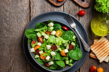 Bir tabak ıspanak, vişneli domates ve peynir.