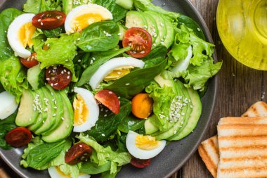 Ispanaklı salata, avokado, tabakta domates. Vejetaryen salatası