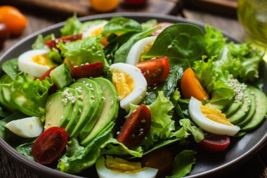 Ispanaklı salata, avokado, tabakta domates. Vejetaryen salatası