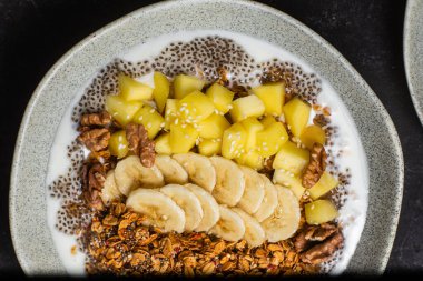 Yoğurtlu granola, mango, muz ve chia.