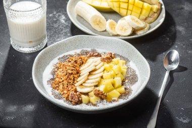 Yoğurtlu granola, mango, muz ve chia.