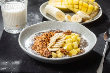 Yoğurtlu granola, mango, muz ve chia.