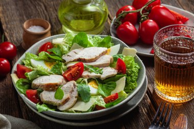 Tavuk fileto salatası, yumurta, domates ve peynir tabakta. Sezar salatası