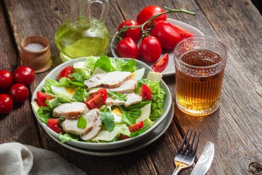 Tavuk fileto salatası, yumurta, domates ve peynir tabakta. Sezar salatası