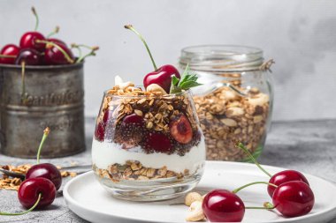 Bir bardak yoğurt ve kirazlı granola.