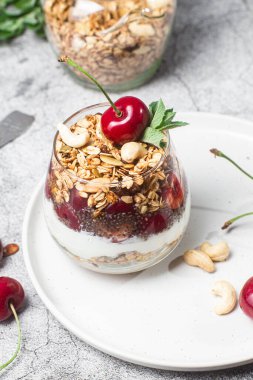 Bir bardak yoğurt ve kirazlı granola.