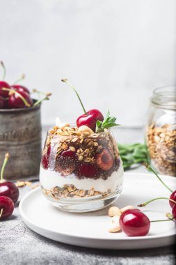 Bir bardak yoğurt ve kirazlı granola.
