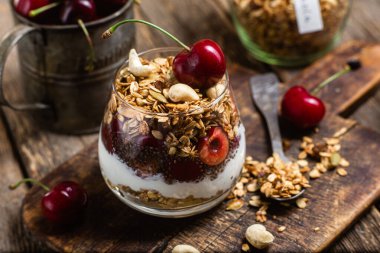 Bir bardak yoğurt ve kirazlı granola.