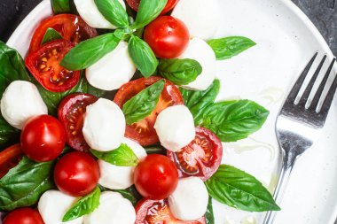 Domates, mozzarella ve fesleğenli caprese salatası.