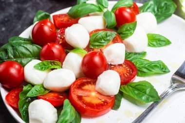 Domates, mozzarella ve fesleğenli caprese salatası.