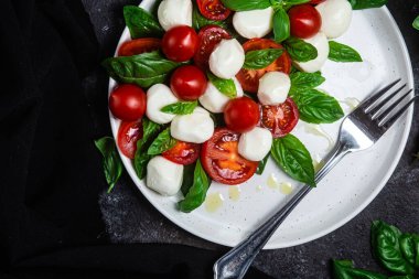 Domates, mozzarella ve fesleğenli caprese salatası.