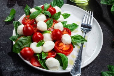 Domates, mozzarella ve fesleğenli caprese salatası.