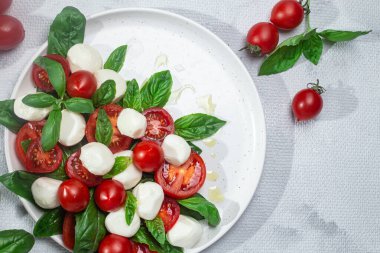 Domates, mozzarella ve fesleğenli caprese salatası.