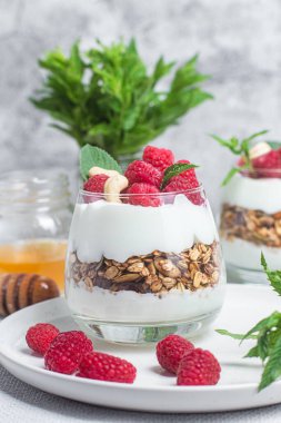 Yoğurtlu granola ve bir bardak ahududu.