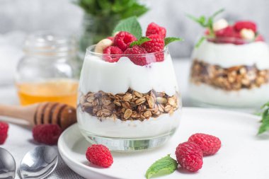 Yoğurtlu granola ve bir bardak ahududu.