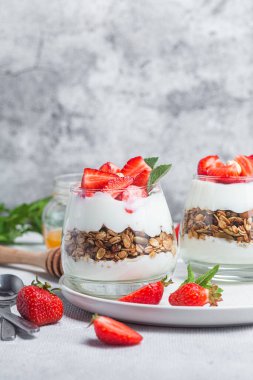 Bir bardakta yoğurt ve çilekli granola.