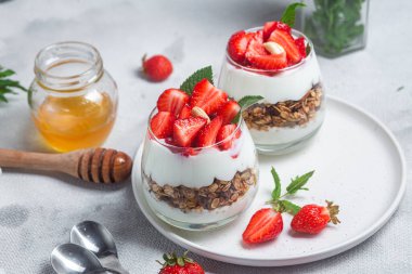 Bir bardakta yoğurt ve çilekli granola.