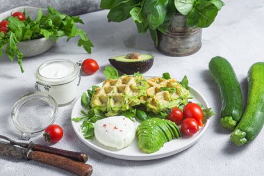 Kabaklı waffle, haşlanmış yumurta, avokado ve vişneli domates.