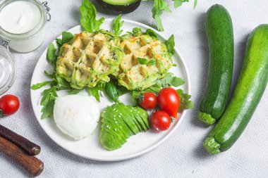 Kabaklı waffle, haşlanmış yumurta, avokado ve vişneli domates.