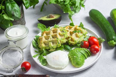 Kabaklı waffle, haşlanmış yumurta, avokado ve vişneli domates.