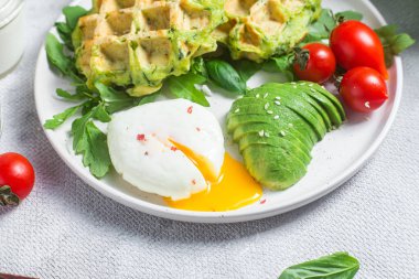 Kabaklı waffle, haşlanmış yumurta, avokado ve vişneli domates.