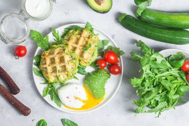 Kabaklı waffle, haşlanmış yumurta, avokado ve vişneli domates.