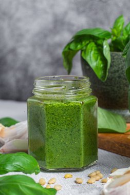 Masadaki cam kavanozda pesto sosu. Basil