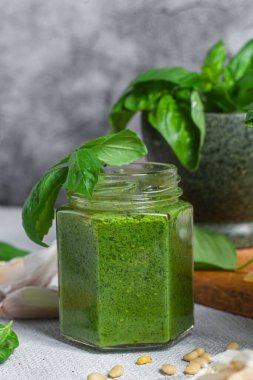 Masadaki cam kavanozda pesto sosu. Basil
