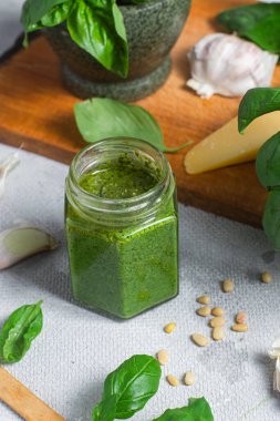 Masadaki cam kavanozda pesto sosu. Basil