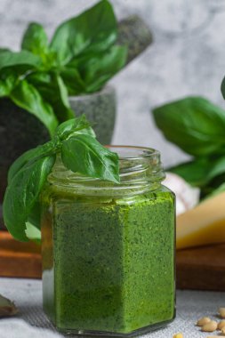 Masadaki cam kavanozda pesto sosu. Basil
