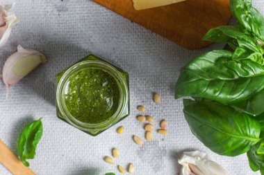 Masadaki cam kavanozda pesto sosu. Basil