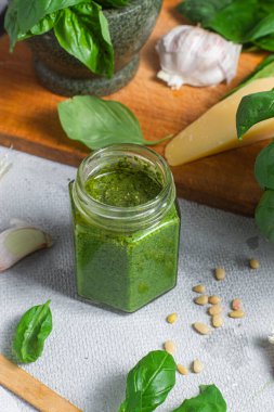 Masadaki cam kavanozda pesto sosu. Basil