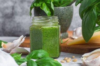 Masadaki cam kavanozda pesto sosu. Basil