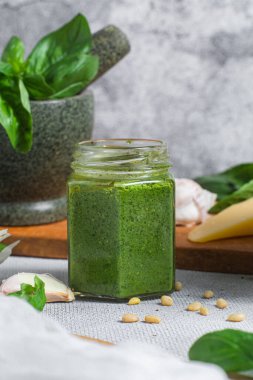 Masadaki cam kavanozda pesto sosu. Basil