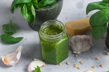 Masadaki cam kavanozda pesto sosu. Basil