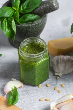 Masadaki cam kavanozda pesto sosu. Basil