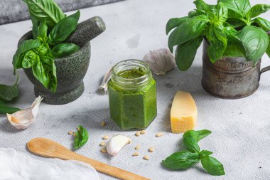 Masadaki cam kavanozda pesto sosu. Basil
