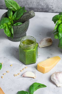 Masadaki cam kavanozda pesto sosu. Basil